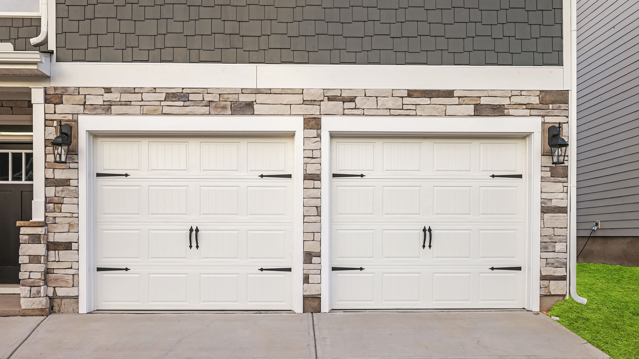 Two separate garage doors accented with stone.
