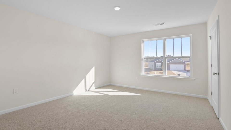 Bedroom with carpet and windows.