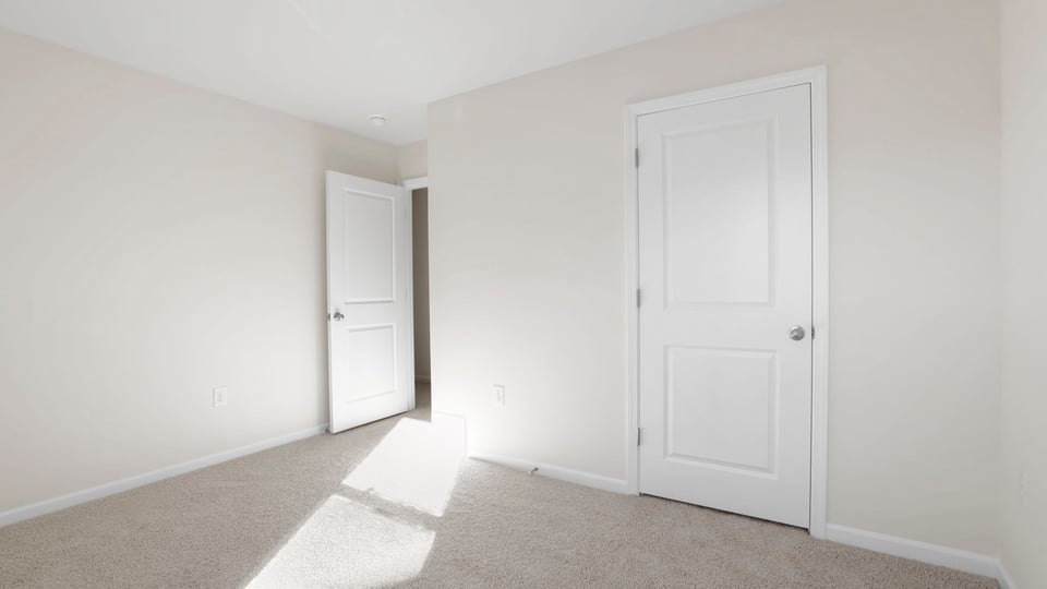 Bedroom with carpet and windows.
