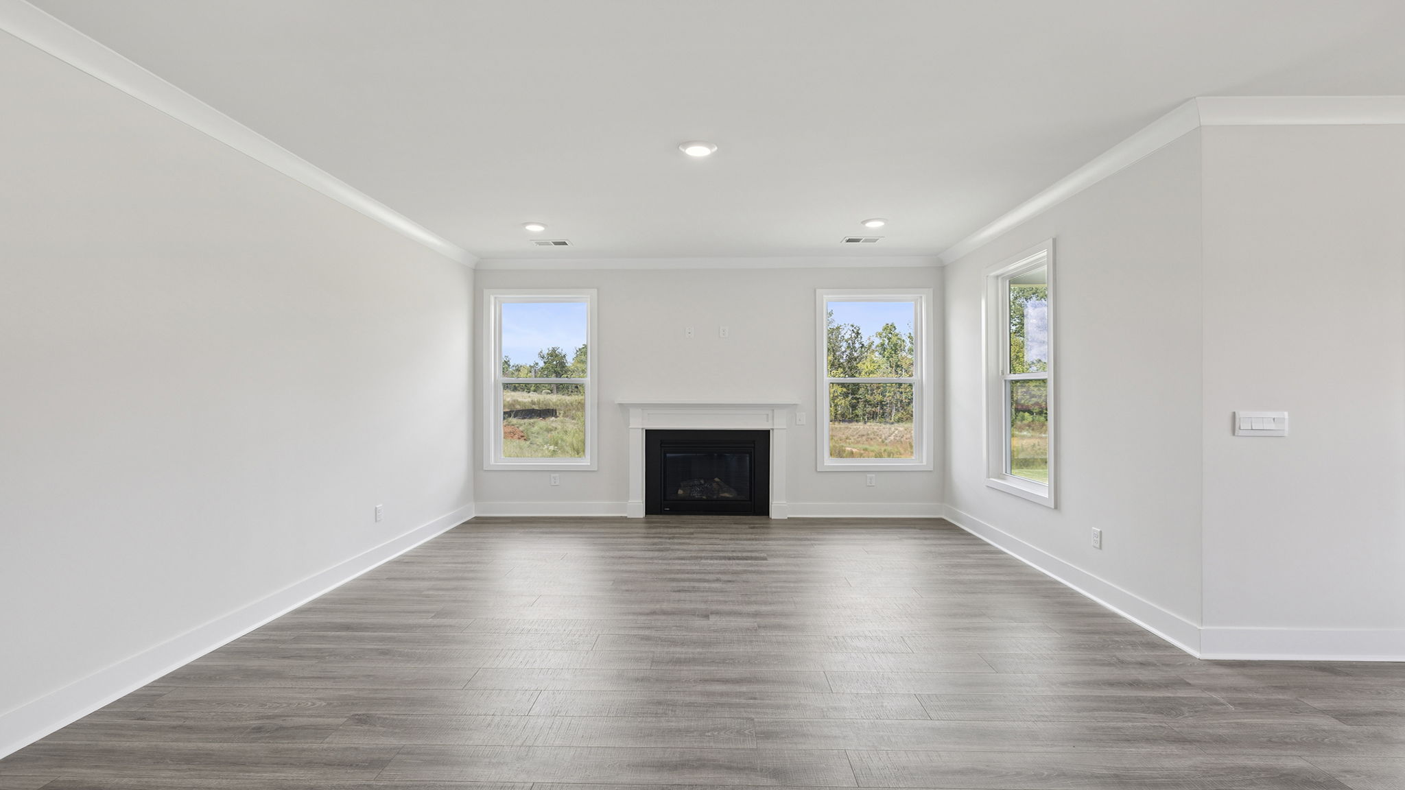 View of the family room with large windows and gas log fireplace.