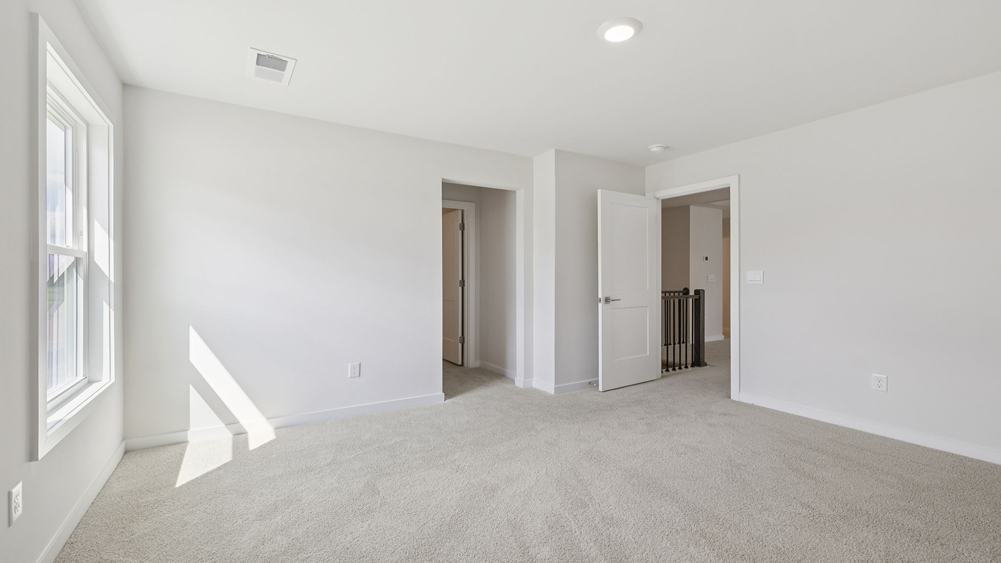 Bedroom with two large windows and access to the hall bathroom.