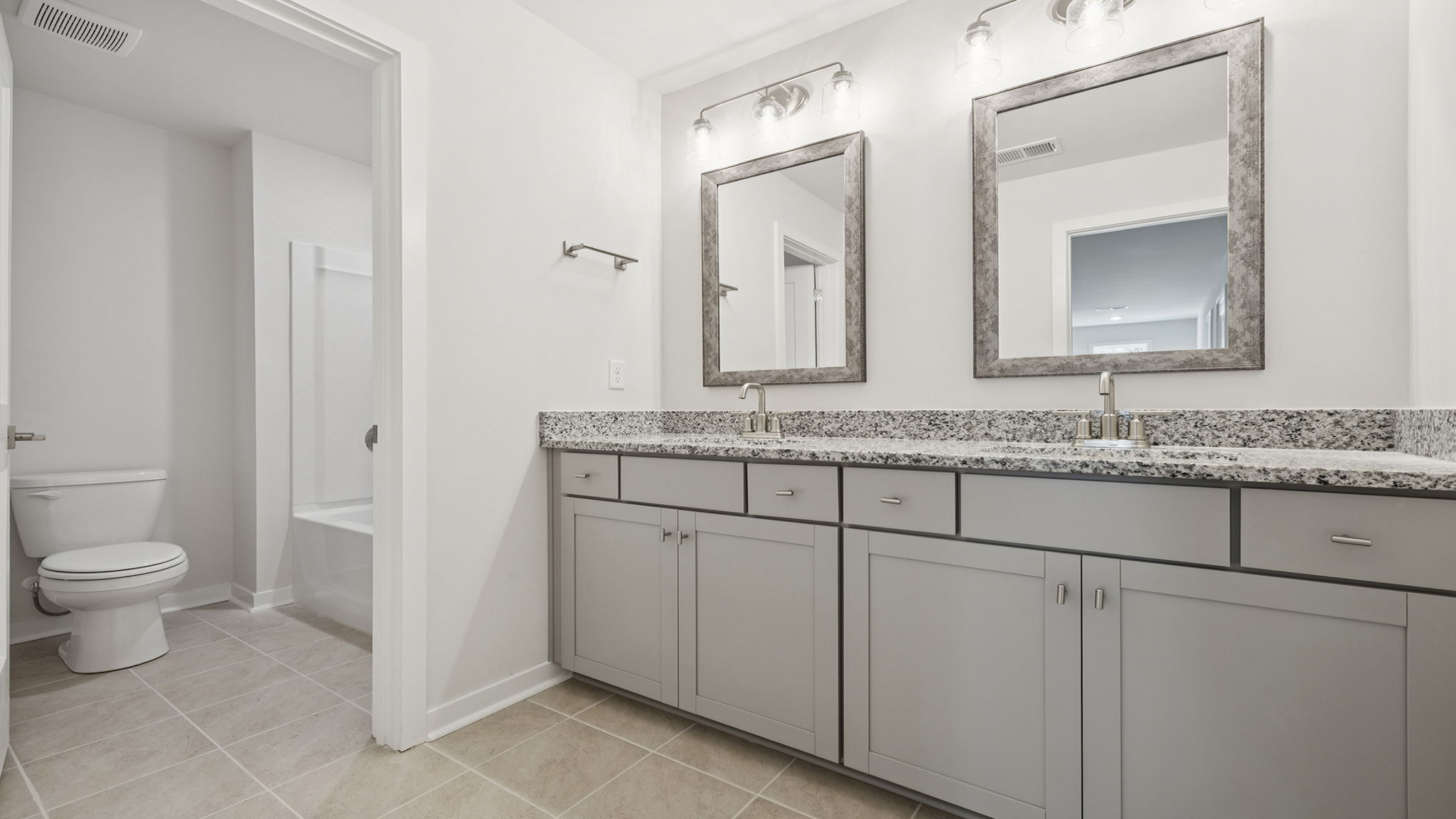 Primary bathroom with dual sink vanity and water closet.