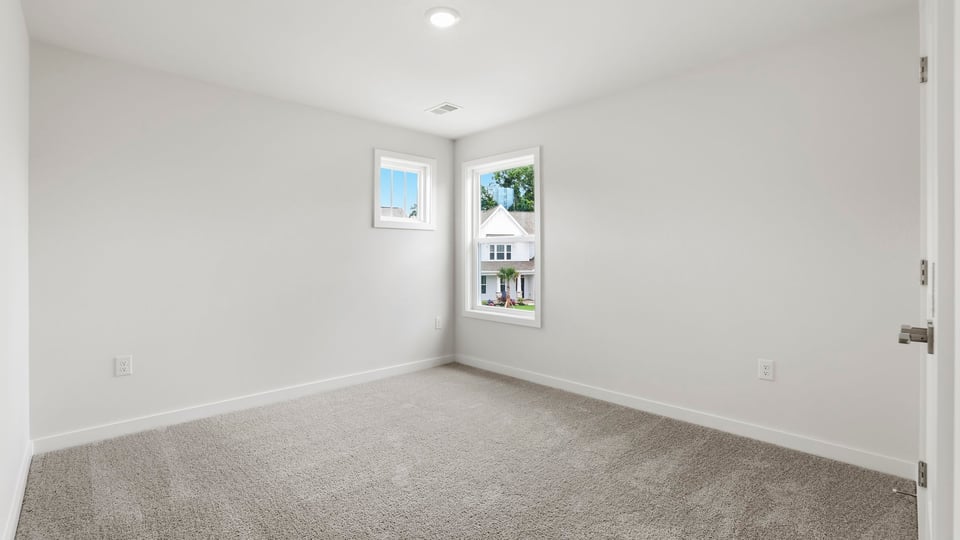 Bedroom with carpet and windows.