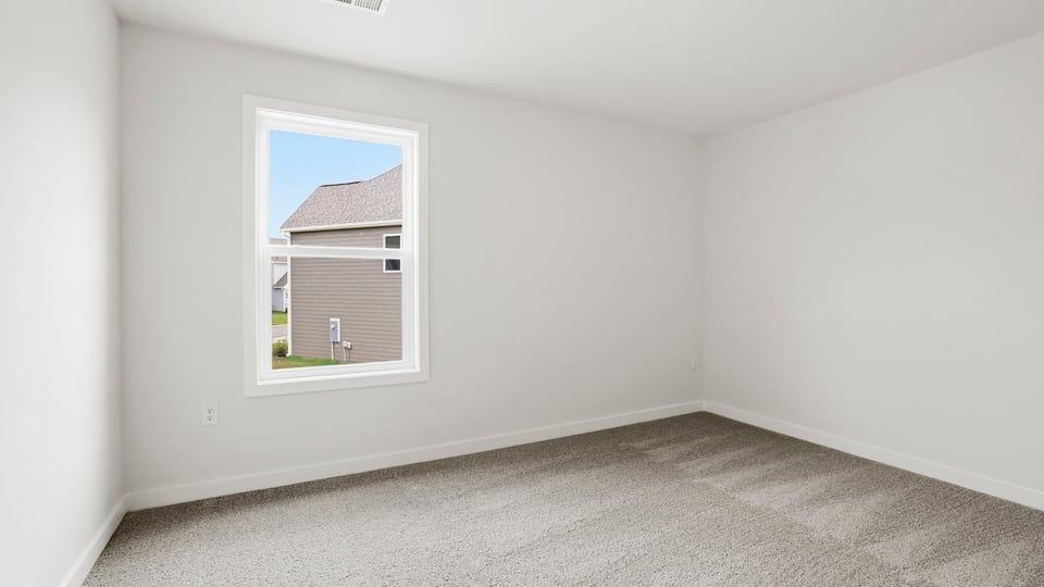 Bedroom with carpet and windows.