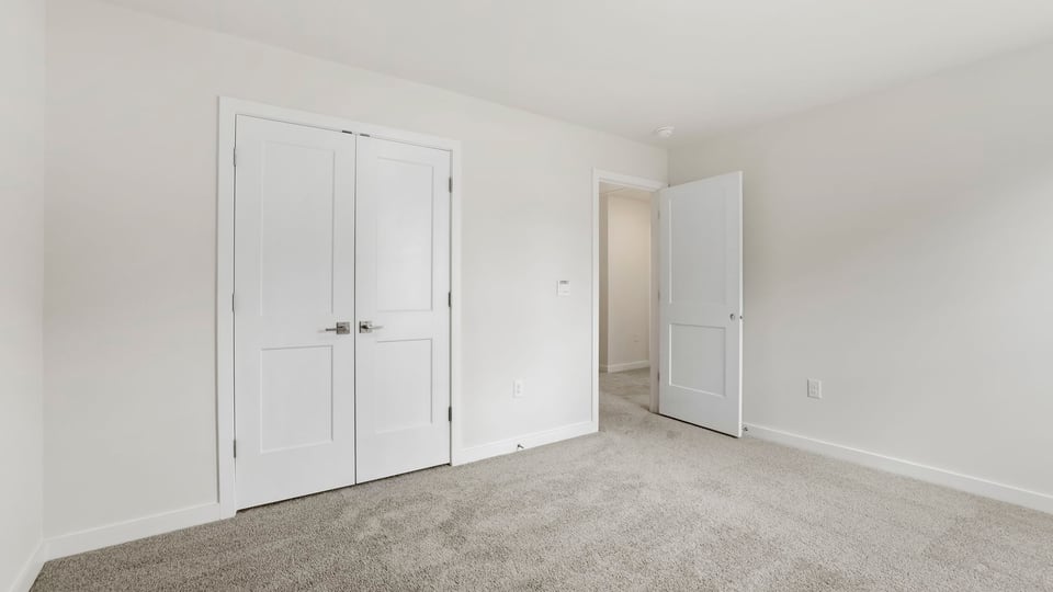 Bedroom with carpet and windows.