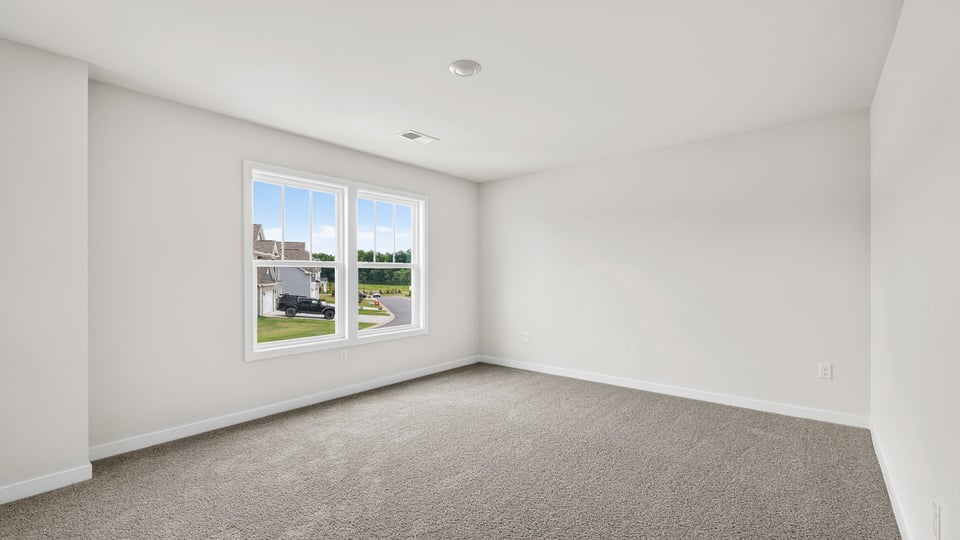 Bedroom with carpet and windows.