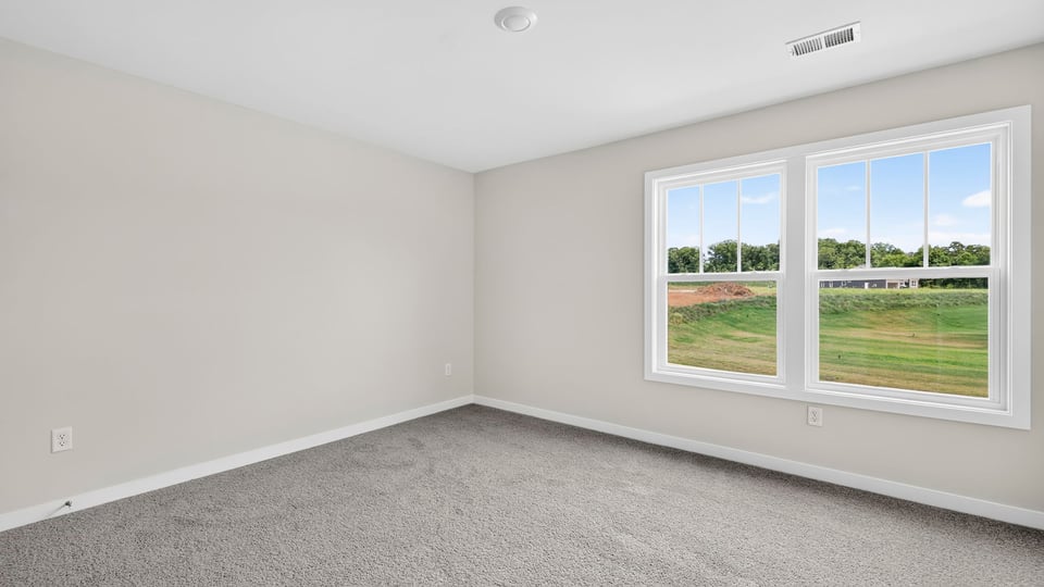 Bedroom with carpet and windows.