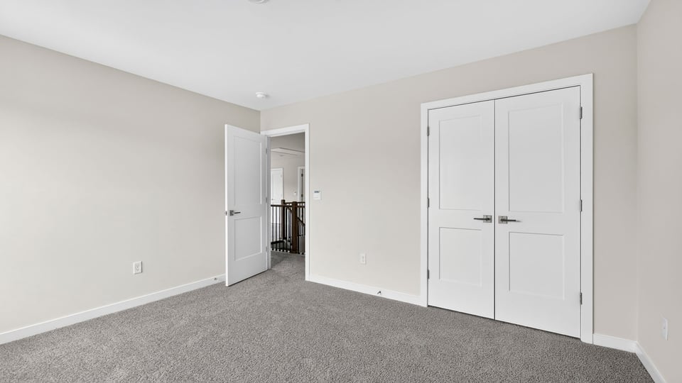Bedroom with carpet and windows.