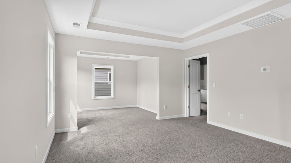 Bedroom with carpet and windows.