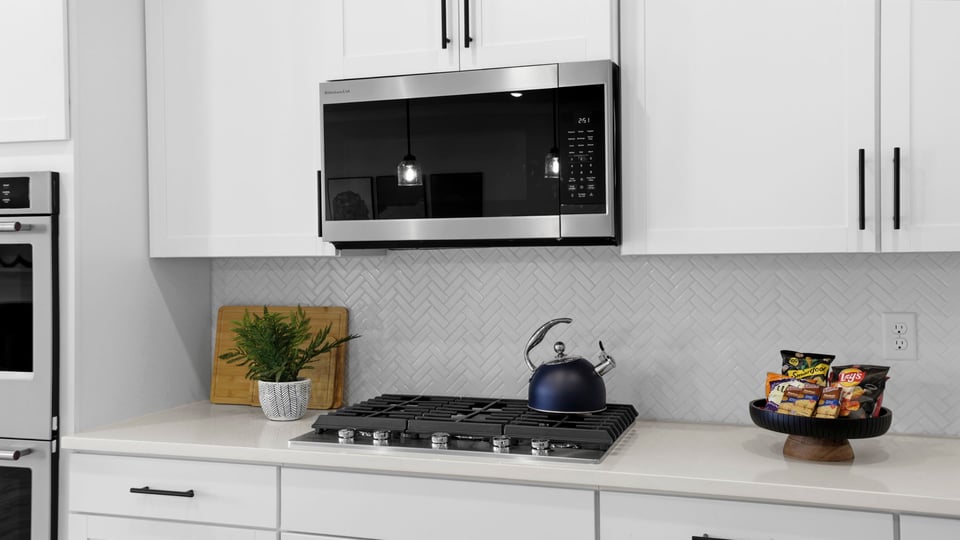 Kitchen and island with stainless steel appliances.