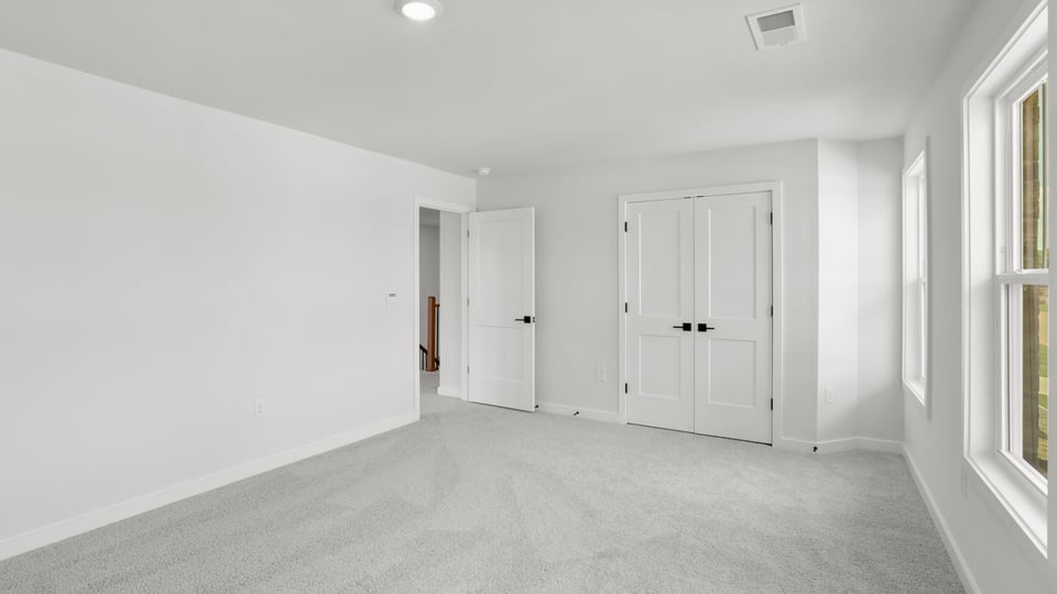 Bedroom with carpet and window.