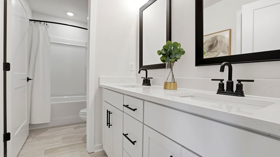 Bathroom with double vanity sink and walk in shower.