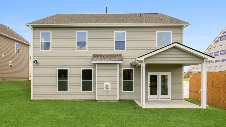 Back exterior of home with large backyard.