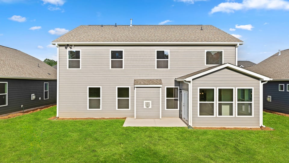 Back exterior of home with large backyard.