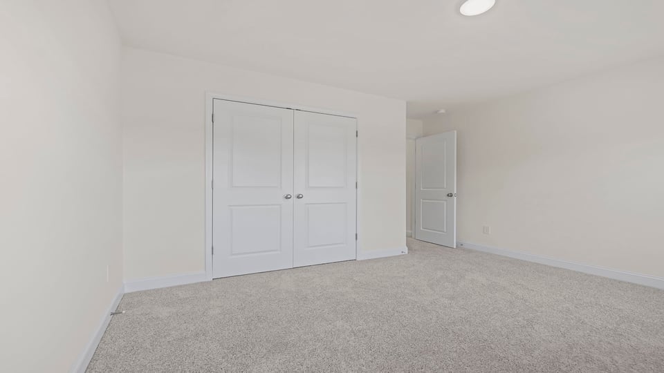Bedroom with carpet and windows.
