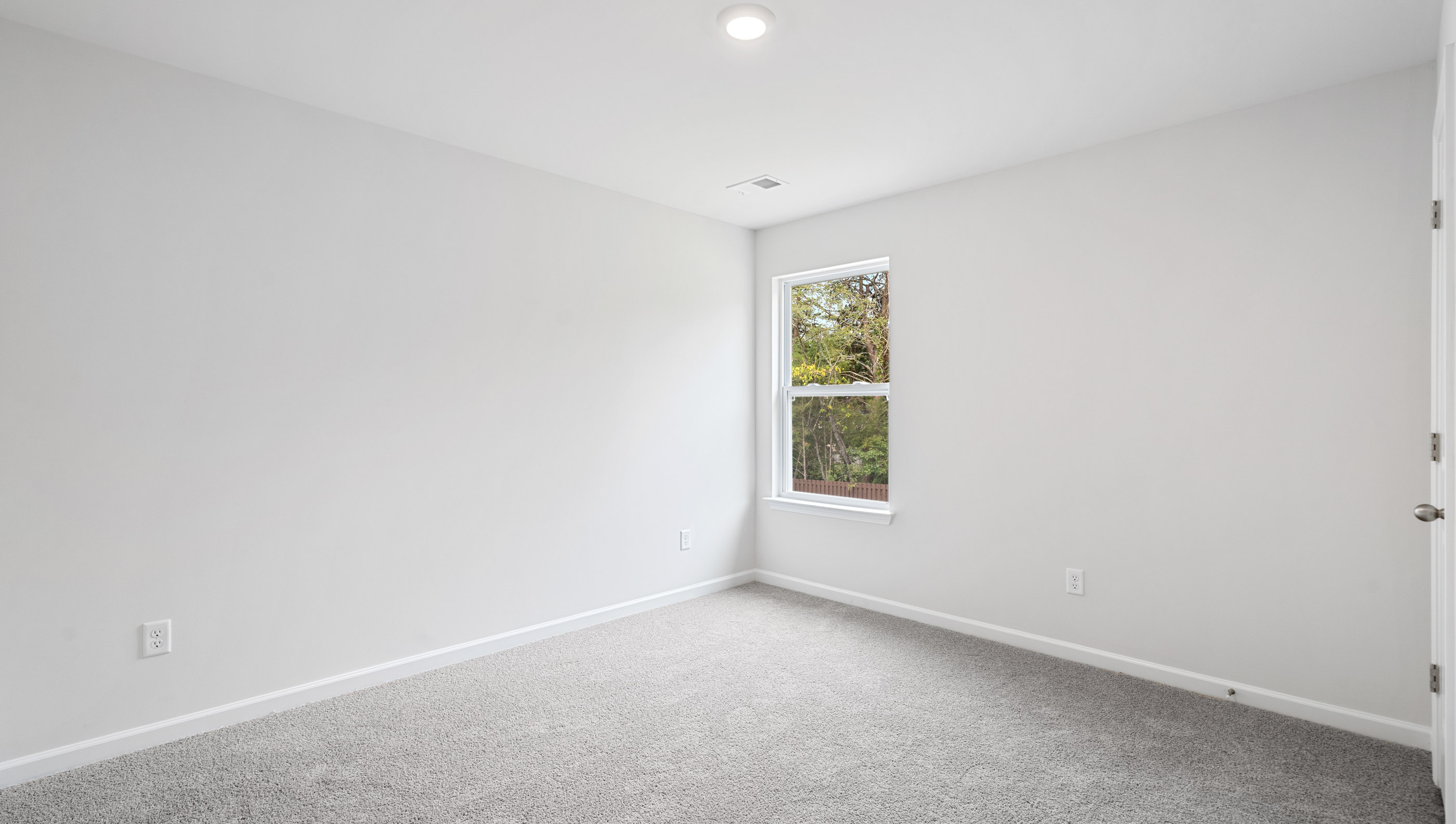 Bedroom with carpet and window.