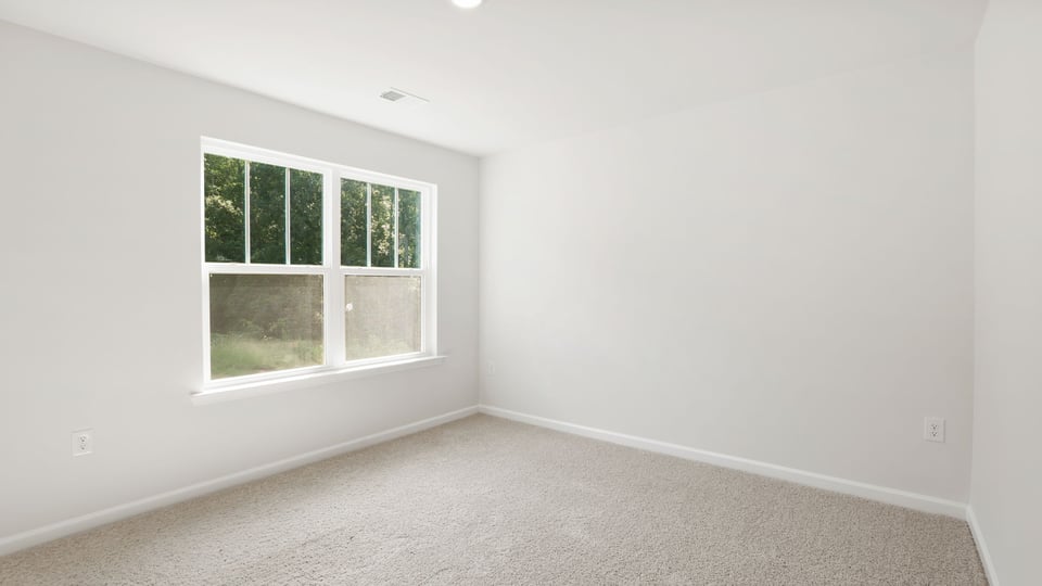 Bedroom with carpet and window.