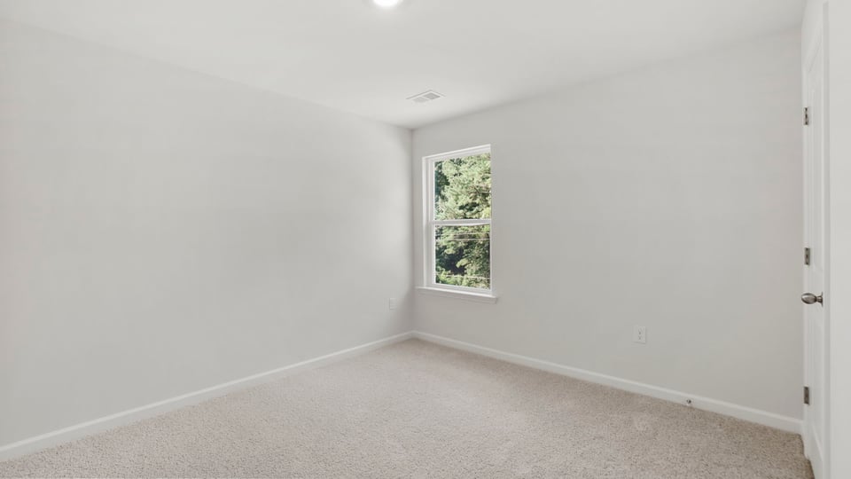 Bedroom with carpet and window.