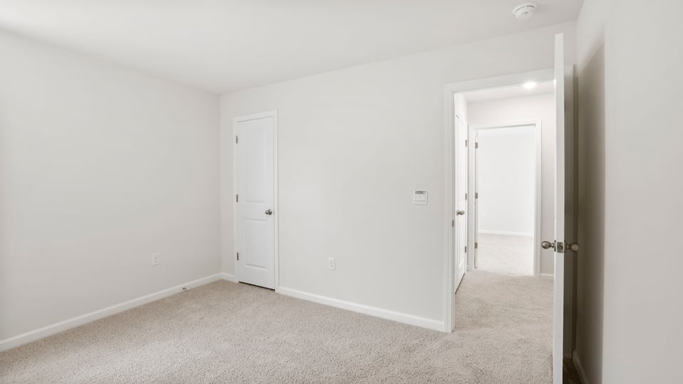 Bedroom with carpet and window.