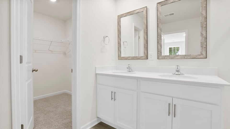 Bathroom with double vanity sink and walk in closet.