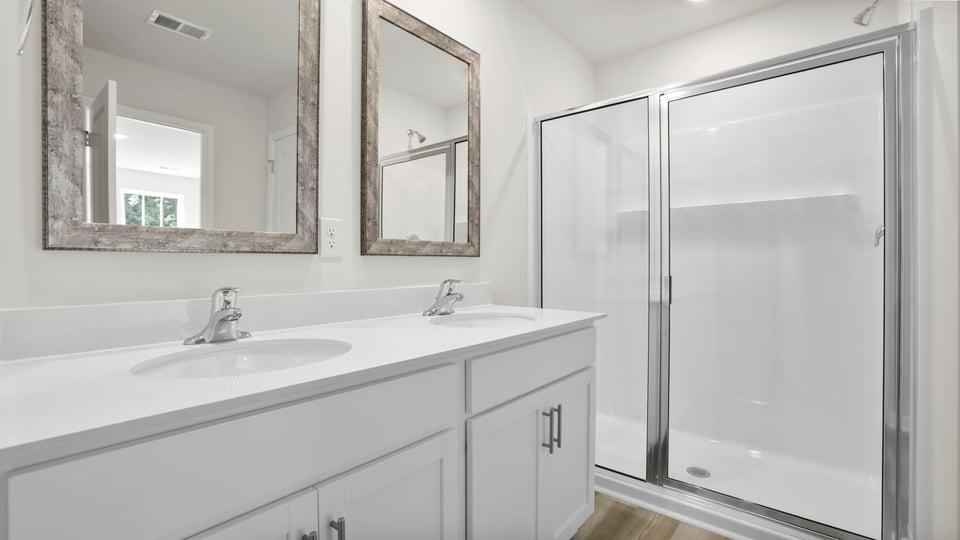 Bathroom with double vanity sink and walk in shower.