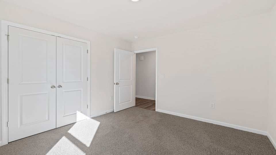 Bedroom with window and carpet.