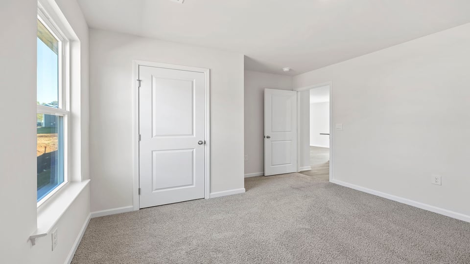 Bedroom with window and carpet.