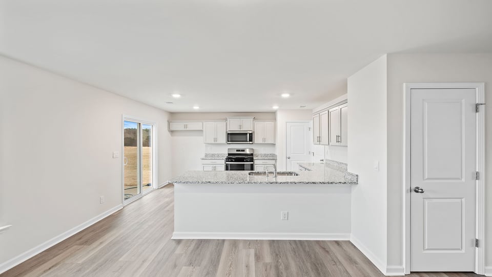View of the open kitchen with lots of windows and recessed lighting.