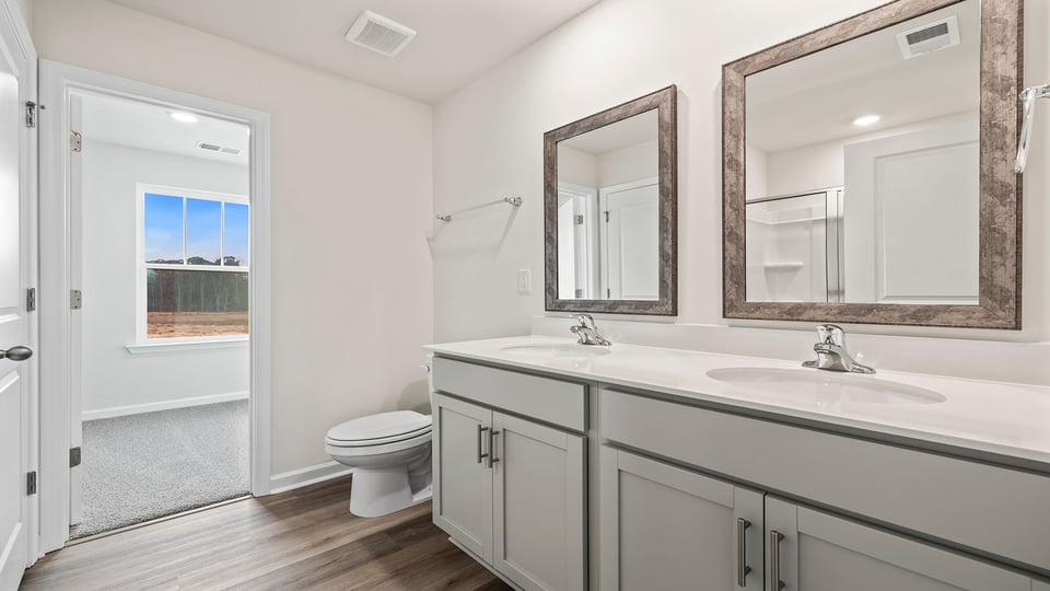 Primary bathroom with dual sink vanity and mirrors.