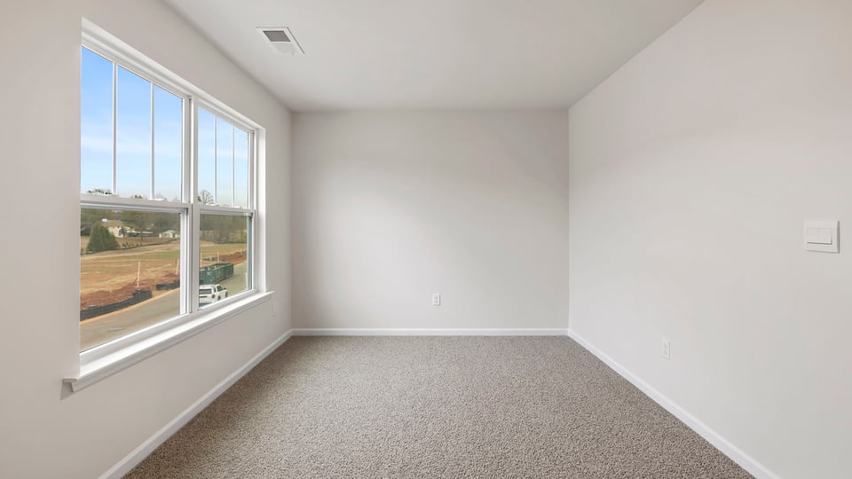 Bedroom with window and carpet.