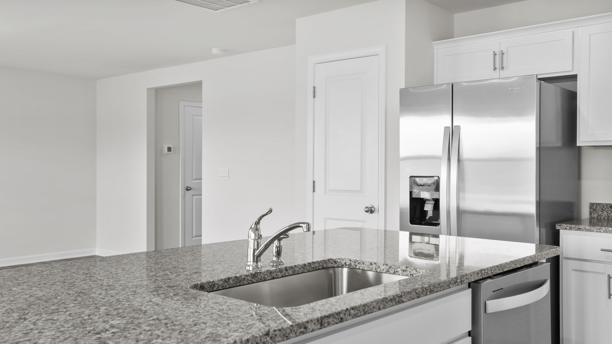 Kitchen island hosts the sink and dishwasher.