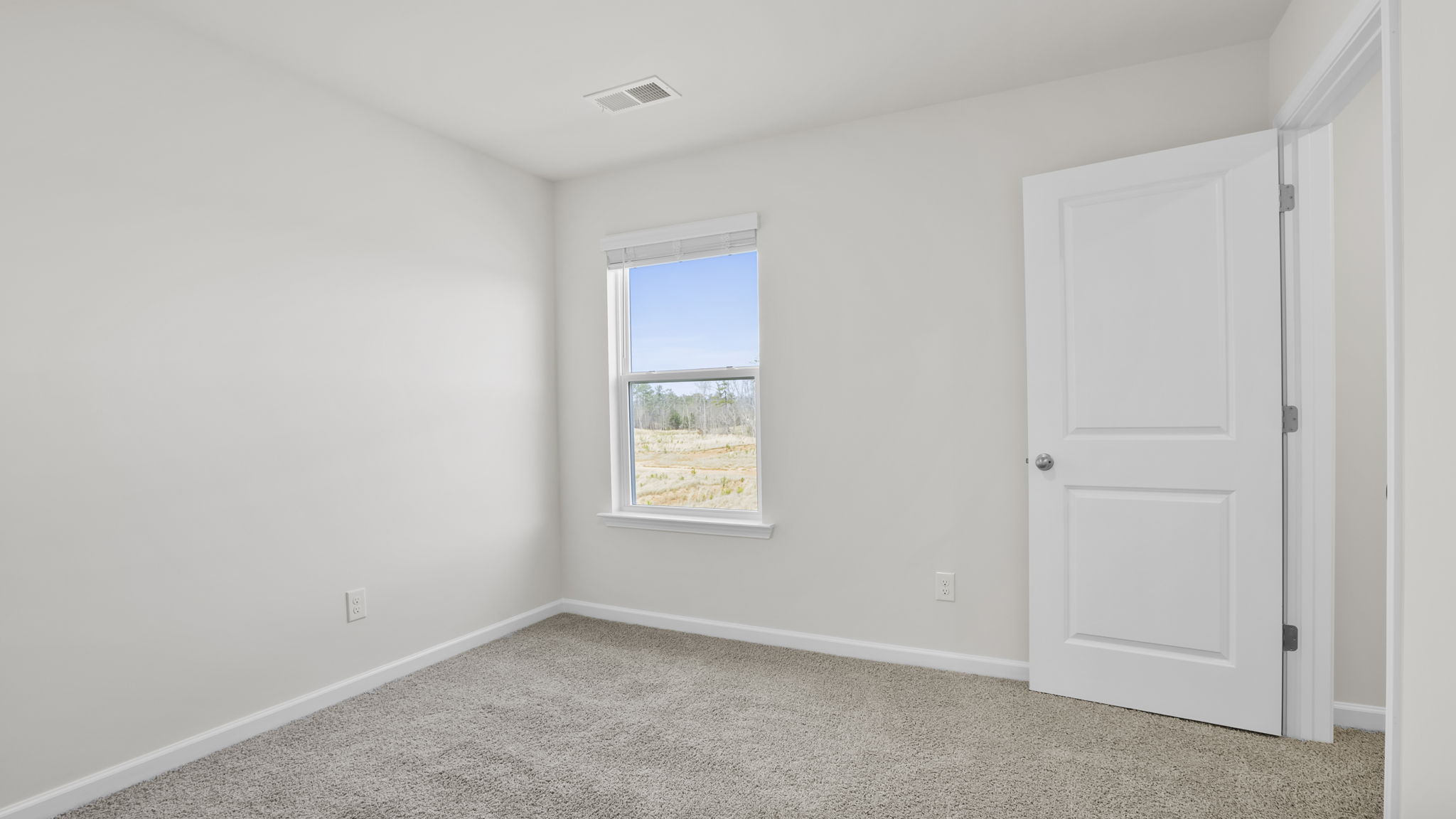 Bedroom with window and carpet.