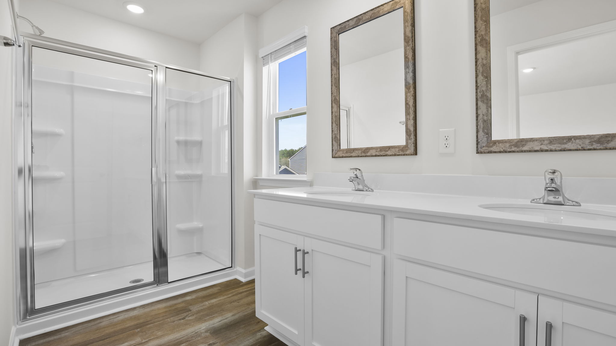 Primary bath with dual sink vanity and walk-in shower.