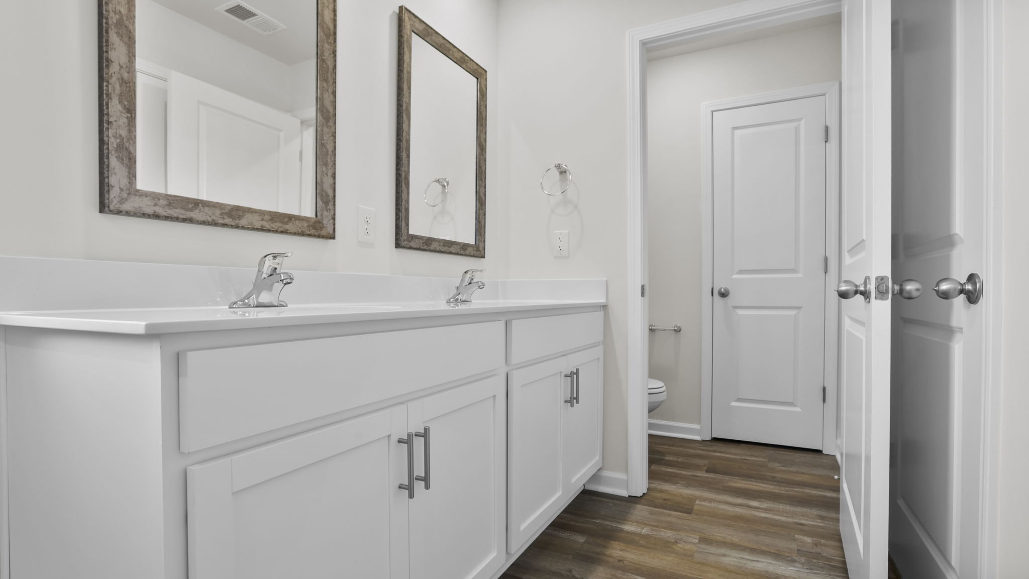 Primary bath with dual sink vanity and walk-in closet.