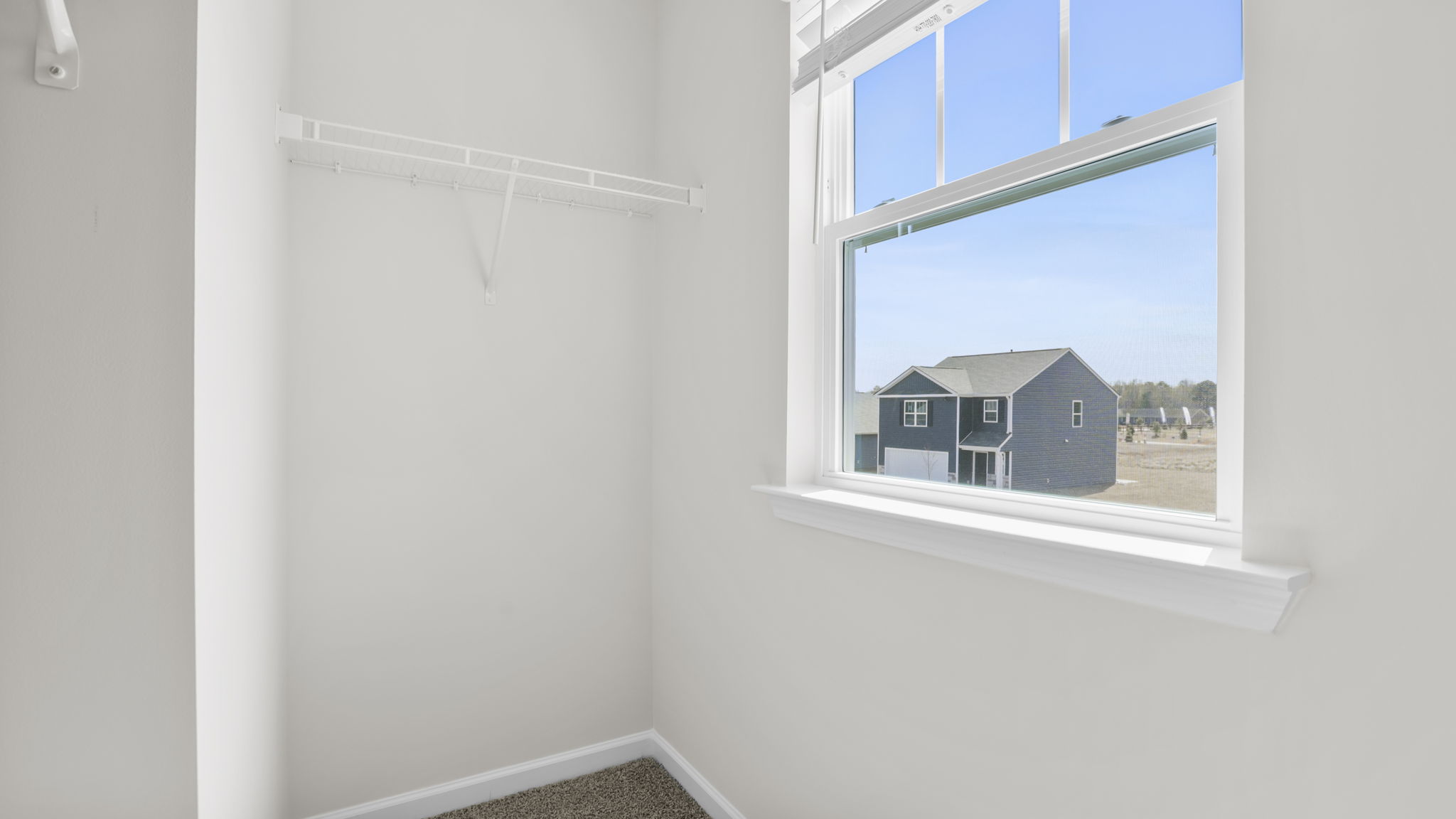 Primary bedroom walk-in closet with window.