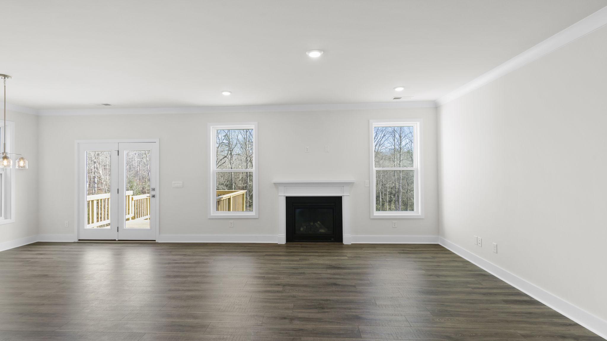 Family room with two large windows and gas log fireplace.