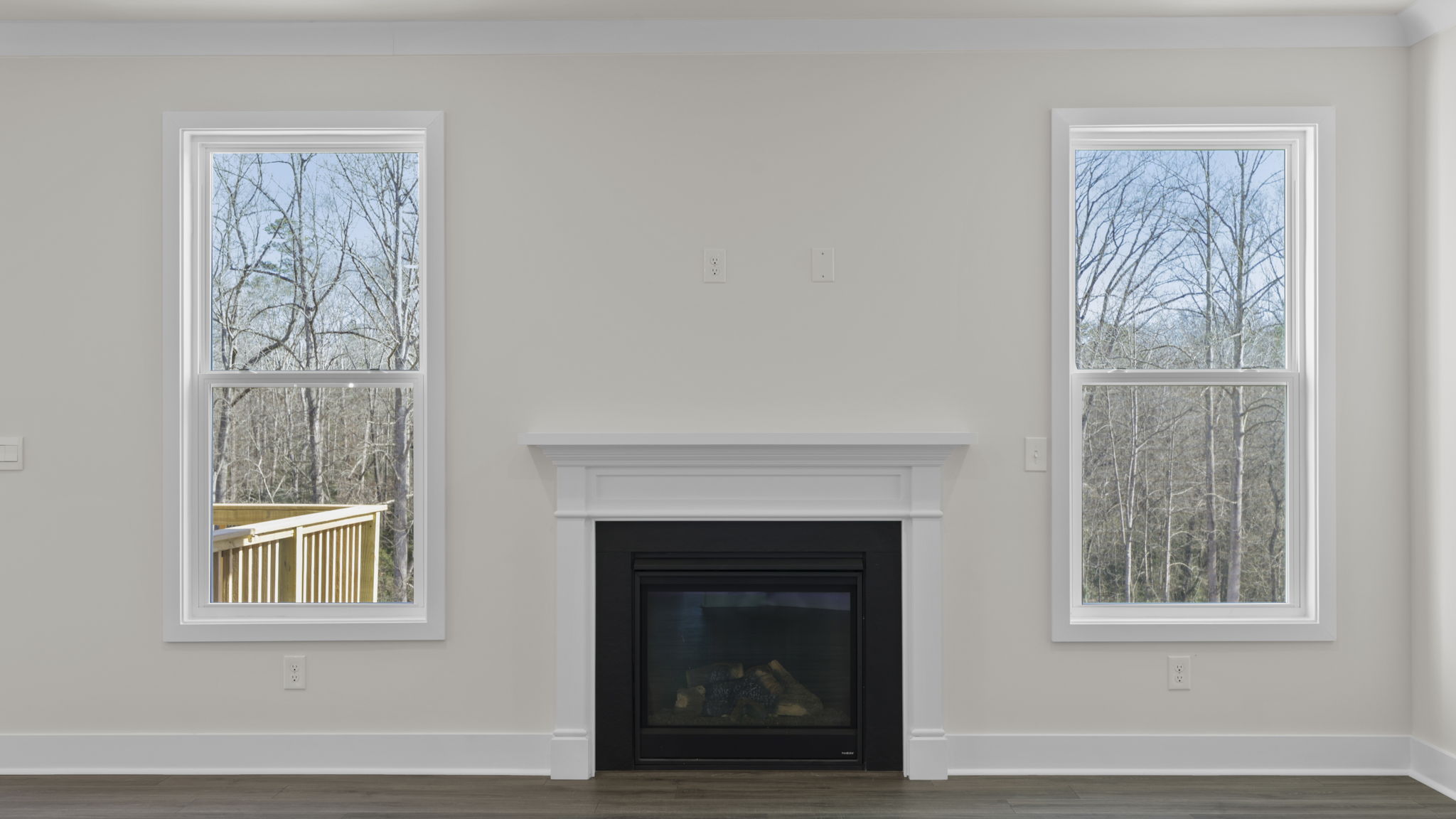 Gas log fireplace accented by two large windows.