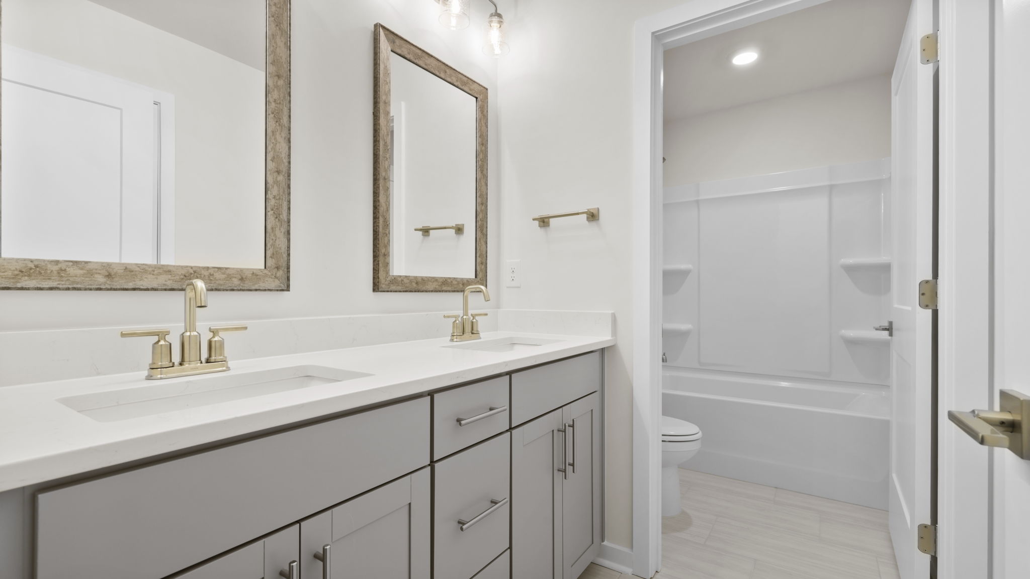 Hall bathroom with dual sink vanity and separate shower area.