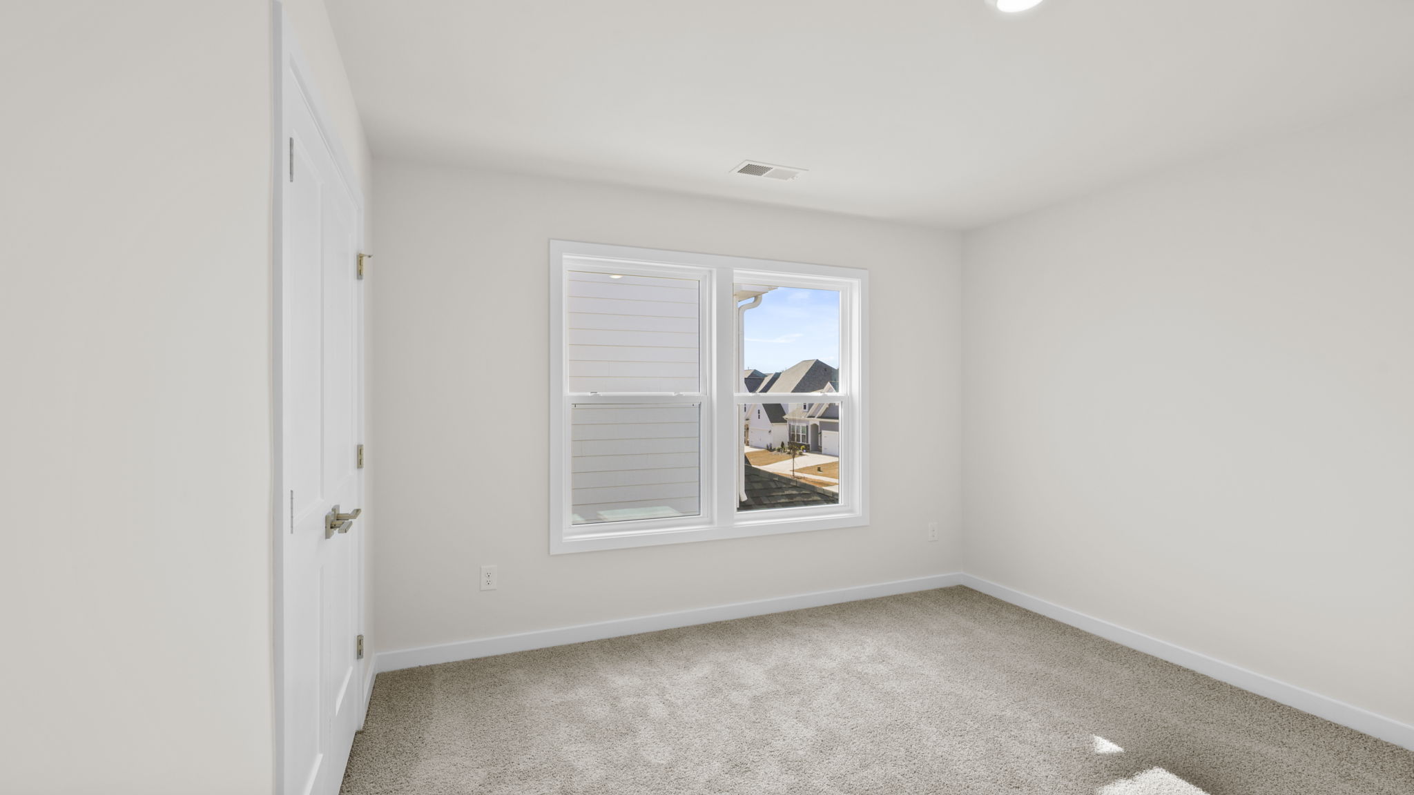 Bedroom with window and carpet.