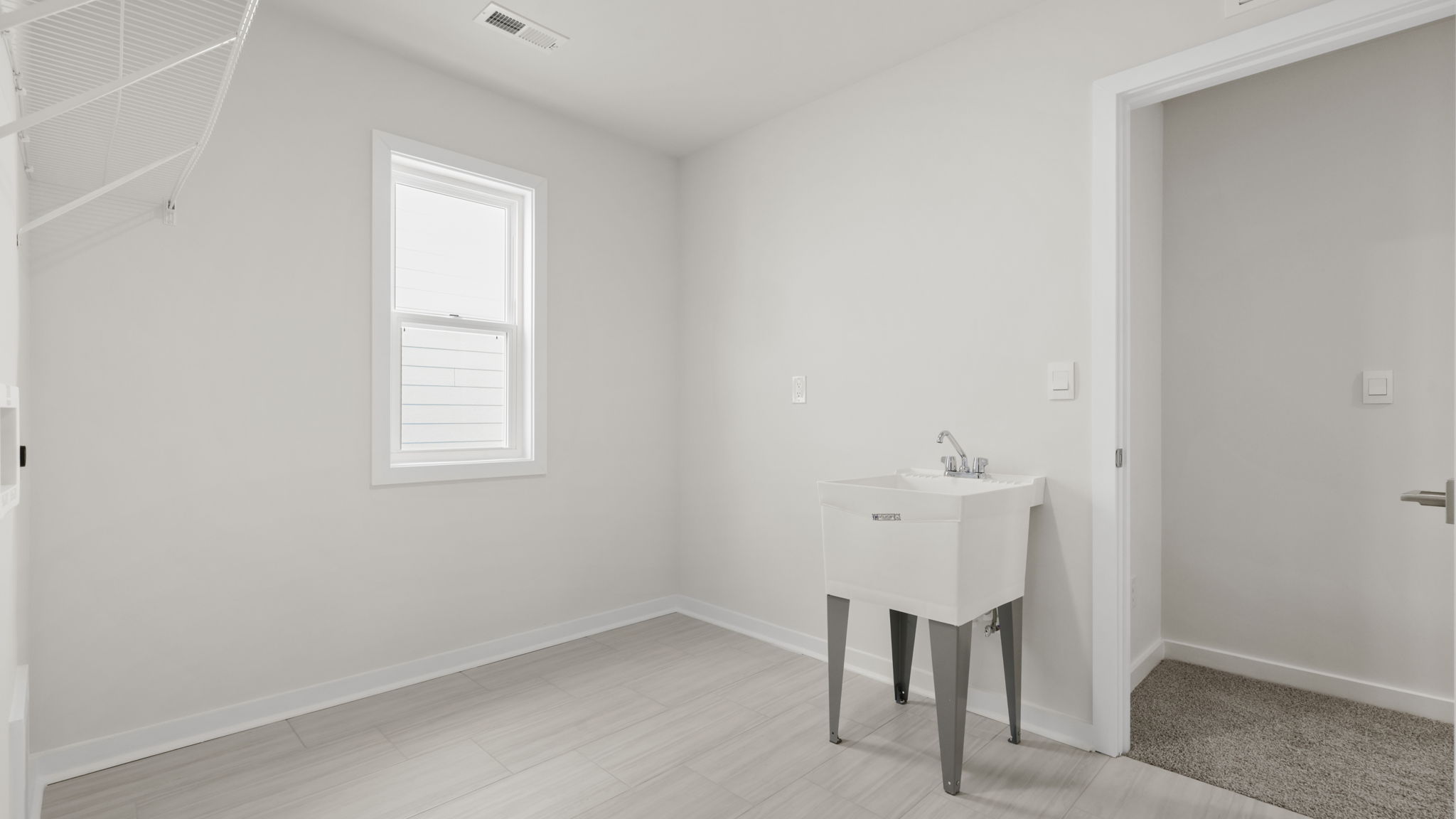 Walk-in laundry room with sink.