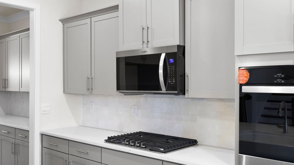 Stainless gas stovetop, microwave, and electric double ovens.