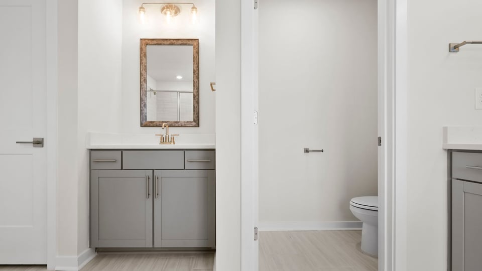 View of primary bathroom his and her vanities and separate toilet area.