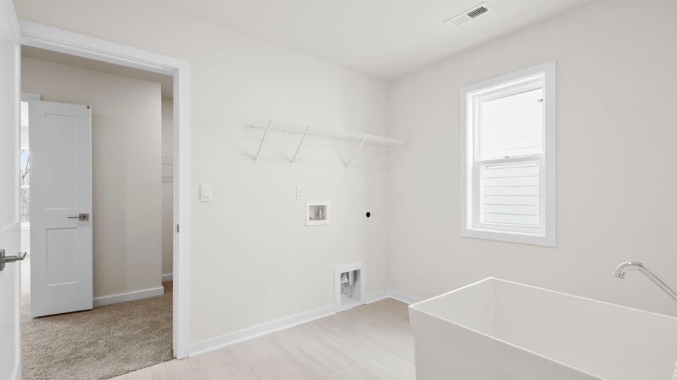 View of walk-in laundry room with shelving and sink.