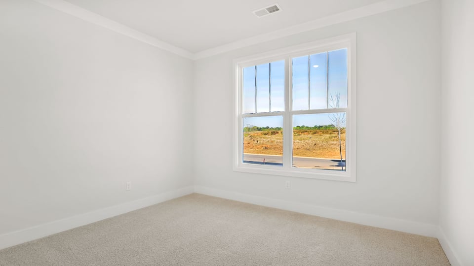 Bedroom with carpet and window.
