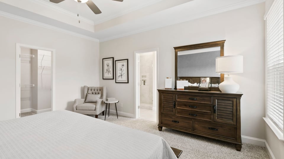 Primary bedroom with carpet and window.
