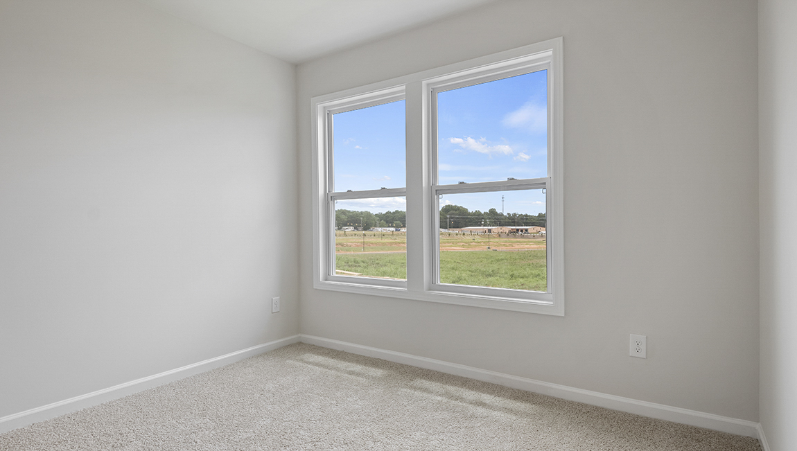 Bedroom with carpet and window.