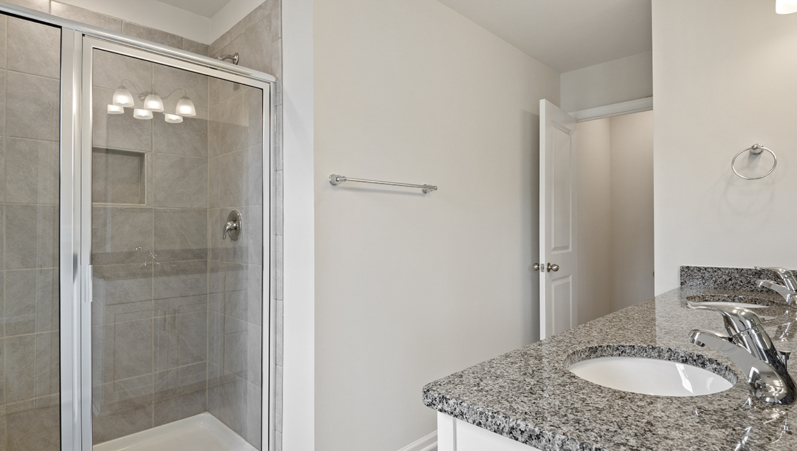 Primary bathroom with vanity and walk in shower.