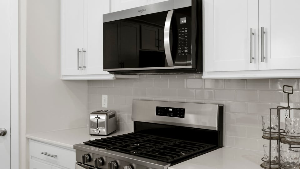 Kitchen with quartz countertops and stainless steel appliances.