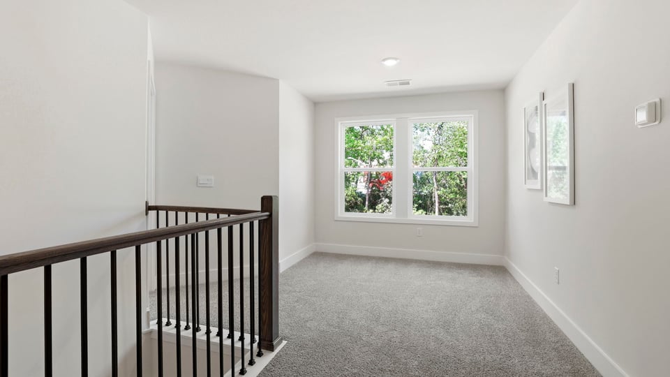 Loft area with carpet and window.