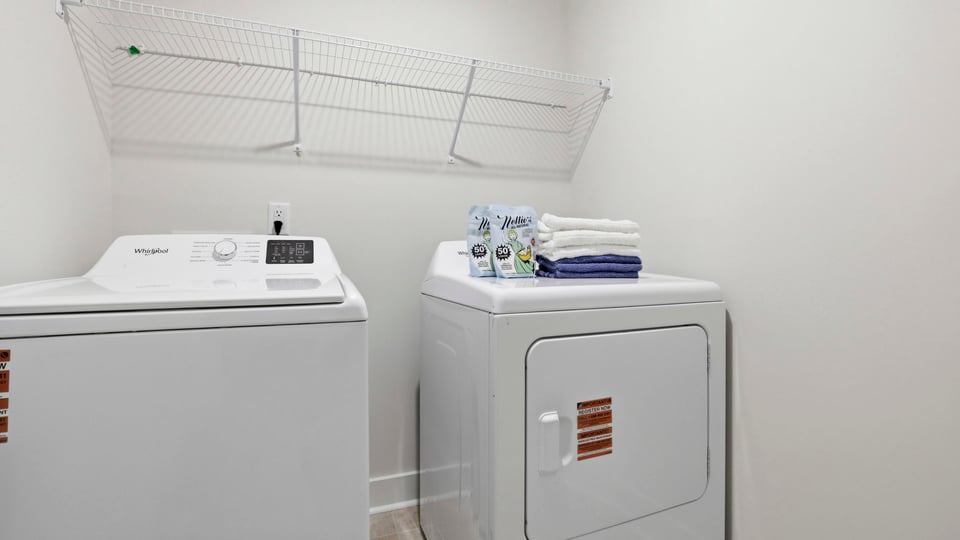 Laundry room with hanging storage racks.